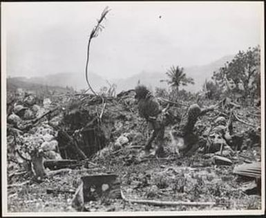 Marines on Saipan, protected by a small bank, lob grenades at the Japanese positions