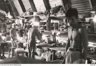 Japanese prisoners held at the RAN War Criminal Compound at an RAN shore base are working in the tailors shop at the compound. All repairs were carried out and all new garments made in the tailor's ..