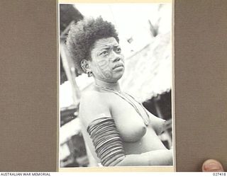 WANIGELA, NEW GUINEA. 1942-10. NATIVE WOMAN AT WANIGELA MISSION. NOTE THE UNIQUE FACIAL TATTOOING