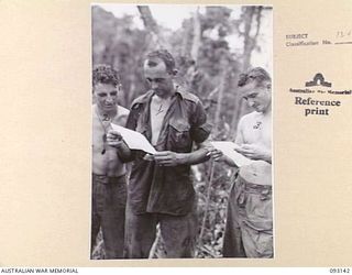 WEWAK AREA, NEW GUINEA, 1945-06-17. CPL L. ALLEN (1), PTE K.N. WALDRON (2) AND PTE L.L. HAYMAN (3), MEMBERS OF 2/8 INFANTRY BATTALION, READING LETTERS FROM HOME. CPL ALLEN WAS WOUNDED IN THE ARM ..