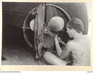 PURUATA ISLAND, SOUTH BOUGAINVILLE. 1945-05-29. CRAFTSMAN R.O. BOLGER, 42 LANDING CRAFT COMPANY, PUTTING ON A BARGE PROPELLER. THIS COMPANY HAS PLAYED AN IMPORTANT PART IN SUPPLYING FORWARD AREAS ..