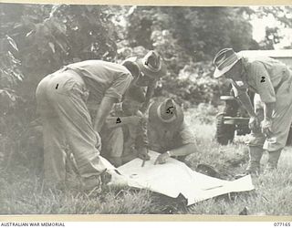 JACQUINOT BAY, NEW BRITAIN. 1944-11-21. SENIOR AUSTRALIAN SERVICE OFFICERS CHECKING OVER THE PLANS FOR THE NEW AIRSTRIP NEAR THE PALMALMAL PLANTATION. IDENTIFIED PERSONNEL ARE:- NX171 BRIGADIER ..
