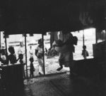 An elderly woman, who fainted at her husbands funeral, being carried into a nearby house