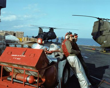 Crew members stand by a damage control vehicle on the flight deck of the amphibious assault ship USS GUAM (LPH 9) during flight operations off the coast of Beirut. The ship is providing support to US Marines deployed in Lebanon as part of a multi-national peacekeeping force following confrontation between Israeli forces and the Palestine Liberation Organization