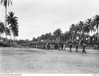 Aitape, New Guinea. 1945-02-23. Personnel of the 2/4th Infantry Battalion, 19th Australian Army Brigade, give eyes right to the General Officer Commanding, 6th Australian Division, during a march ..