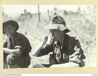 BOGADJIM, NEW GUINEA. 1944-04-26. VX141664 PRIVATE H. QUAIFE (1), WITH VX144705 PRIVATE J. P. CORNELL (2), MEMBERS OF A PATROL DRAWN FROM C COMPANY, 57/60TH INFANTRY BATTALION ENJOYING A CUP OF ..