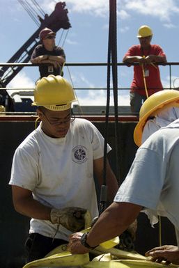 Contract workers from the Crowley 450-10 barge secure equipment to be lifted aboard, during recovery operations for the Japanese fishing vessel Ehime Maru