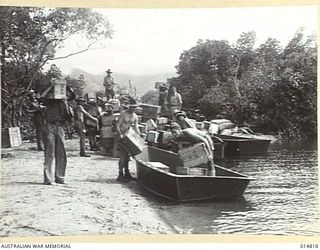 1943-05-07. NEW GUINEA. CANTEEN STORES UNLOADED FROM BARGES IN A NEW GUINEA INLET. (NEGATIVE BY N. BROWN)