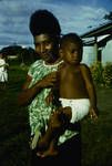 Woman holding a child, the high hair-do very popular in Lae