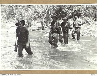 KUMBARUM AREA, NEW GUINEA. 1943-11-06. TROOPS OF THE 2/14TH AUSTRALIAN INFANTRY BATTALION AND THE 2/2ND AUSTRALIAN PIONEER BATTALION CROSSING THE URIA RIVER IN THE RAMU VALLEY. THEY ARE, LEFT TO ..