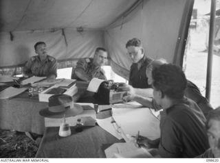 CAPE WOM, NEW GUINEA. 1945-10-19. THE WEWAK WAR CRIMES COMMISSION IN SESSION AT HEADQUARTERS 6 DIVISION. THEY ARE SUMMARISING EVIDENCE FOR SUBSEQUENT WAR TRIALS AGAINST SUSPECTED JAPANESE WAR ..