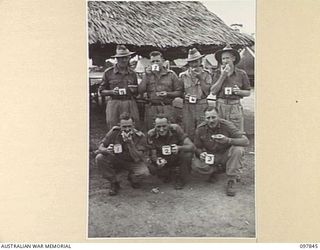 CAPE WOM, WEWAK AREA, NEW GUINEA. 1945-10-13. MEMBERS OF C COMPANY, 2/1 GUARD REGIMENT, ENJOYING TEA AND A SLICE OF JAM TART. IDENTIFIED PERSONNEL ARE:- PRIVATE J.T. COX (1); CORPORAL F.J. CHAPMAN ..