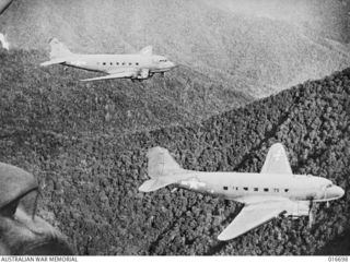 NEW GUINEA. 1944-03-22. DOUGLAS C47 DAKOTA AIRCRAFT OF THE TROOP CARRIER COMMAND PASS OVER THE FINISTERRE RANGE. A SHOT FROM THE DEPARTMENT OF INFORMATION FILM "JUNGLE PATROL"