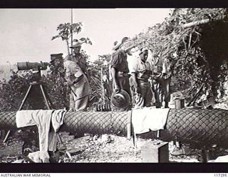 NAURU ISLAND. 1945-09-15. BRIGADIER J. R. STEVENSON DSO, COMMANDING 11TH AUSTRALIAN INFANTRY BRIGADE LOOKING THROUGH A LARGE PAIR OF JAPANESE FIXED BINOCULARS WHILE INSPECTING ENEMY FORTIFICATIONS ..
