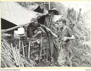 NEW GUINEA. UPPER RAMU VALLEY ADVANCE. 1 NOVEMBER 1943. PTE. G. WHITE OF LEEDERVILLE, WEST AUST., AND PTE. R. WOODHOUSE OF COONA, N.S.W. WITH THEIR BILLIES AT LUNCH TIME AT AN ADVANCED POST. ..