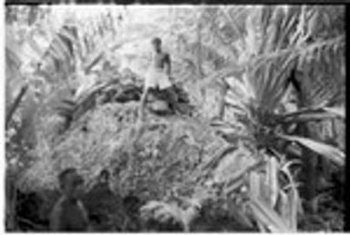 Man on shrine on top of coral outcropping