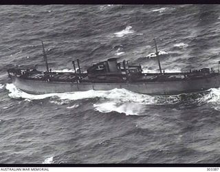 AERIAL PORT SIDE VIEW OF THE NORWEGIAN CARGO MOTOR VESSEL HERSTEIN WHICH SEARCHED FOR SURVIVORS FROM HMAS SYDNEY IN 1941-11. IN 1942-01 SHE TRANSPORTED AUSTRALIAN TROOPS TO NEW GUINEA AND, AFTER ..