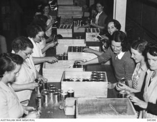 Probably Sydney, NSW. c. 1944. Women, some volunteers, packing tinned food into boxes to be sent to troops in New Guinea. (Copy in album presented to Dr Edith Summerskill p.268)