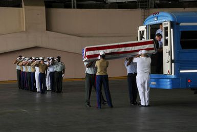 Service members from the United States Pacific Command (USPACOM) carry a flag draped transfer case holding the remains of a service member killed during the Korean War. The remains are being repatriated to American soil during the arrival ceremony. An official delegation headed by Governor Bill Richardson, from the United States, traveled to North Korea to accept the remains from the government. (U.S. Army PHOTO by SGT. Adelita Chavarria Meaad) (Released)