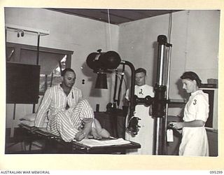 PALMALMAL PLANTATION, JACQUINOT BAY, NEW BRITAIN, 1945-08-14. A PATIENT, SAPPER J.W. PIGGOTT (1), BEING X-RAYED AT THE 2/8 GENERAL HOSPITAL BY STAFF-SERGEANT F.J. TYRELL (2), AND CORPORAL E.M. ..