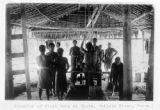 Papua New Guinea, men gather under thatched roof