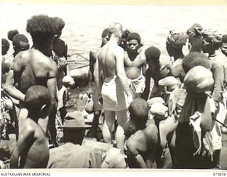 MANAM ISLAND, NEW GUINEA. 1944-09-03. ISLAND NATIVES ENGAGED IN TRADING FRUITT AND VEGETABLES FOR BULLY BEEF AND BISCUITS WITH THE CRW MEMBERS OF THE MEDICAL LAUNCH AM1568 OF THE 4TH SEA AMBULANCE ..