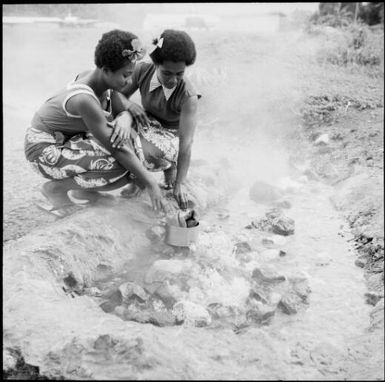 Two Fijian women cooking in a hot springs pool, Fiji, 1966 / Michael Terry