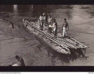 TAVERI RIVER, NEW GUINEA, 1943-09-05. NATIVE PUNT CROSSING THE TAVERI RIVER AT BULLDOG