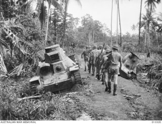 1942-10-01. NEW GUINEA. MILNE BAY. AN AUSTRALIAN INFANTRY SECTION PASS - JAPANESE TYPE 95 HA-GO LIGHT TANKS KNOCKED OUT AT MILNE BAY