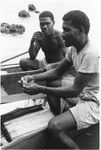 Trading with saltwater (coastal) women in the canoes. Two saltwater men in canoes