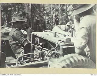 BOUGAINVILLE. 1945-04-26. MAJOR K.MCL.H. ARNOTT, COMMANDING OFFICER, B SQUADRON, 2/4 ARMOURED REGIMENT (1), USING AN ADVANCE LINK INSTALLED IN A JEEP TO KEEP IN TOUCH WITH FORWARD MATILDA TANKS ..