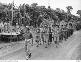 LAE AREA, NEW GUINEA, 1945-06-16. LT-GEN V.A.H. STURDEE, GOC FIRST ARMY (1), TAKING THE SALUTE FROM 2/3 FORESTRY COMPANY, DURING A PARADE, ATTENDED BY ALL ENGINEER COMPANIES UNDER THE COMMAND OF 11 ..