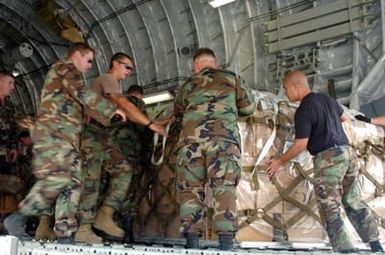 US Navy (USN) Seabees assigned to Naval Mobile Construction Battalion 7 (NMCB-7) load equipment and supplies onto a US Air Force (USAF) C-17 Globemaster III cargo aircraft on the island of Guam (GU), in support of Operation UNIFIED ASSISTANCE