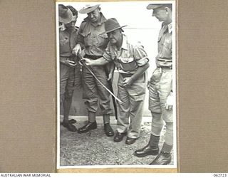 SYDNEY, NSW. 1944-01-12. AUSTRALIAN TROOPS AT THE GENERAL DETAILS DEPOT ADMIRING A SWORD CAPTURED FROM A JAPANESE MAJOR AT SATTELBERG, NEW GUINEA. IDENTIFIED PERSONNEL IS: NX60505 PRIVATE F. J. ..