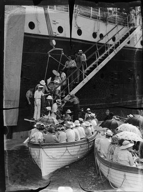 [View of a ship and boats filled with people]