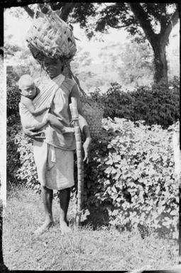 Woman, with a child, in Sarah Chinnery's garden, on way to Boong, the native market, Malaguna Road, Rabaul, New Guinea, ca. 1929 / Sarah Chinnery