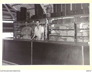 LAE, NEW GUINEA. 1945-11-12. 3. CAPTAIN R.G. STANTON (1) AND WARRANT OFFICER 2 L.J. REES (2) IN THE INTERIOR OF 8 SECTION AUSTRALIAN OFFICERS' SHOP