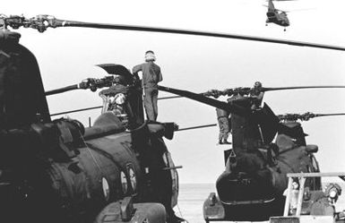 A flight deck crewman performs maintenance on a CH-46 Sea Knight helicopter aboard the amphibious assault ship USS GUAM (LPH 9), during operations off the coast of Beirut, Lebanon