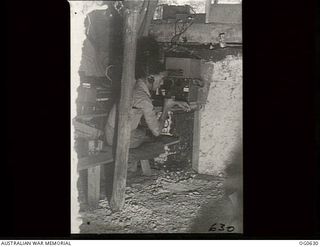 KIRIWINA, TROBRIAND ISLANDS, PAPUA. 1944-01-31. CORPORAL W. GORDON, A RADIO OPERATOR WITH NO. 79 (SPITFIRE) SQUADRON RAAF, AT HIS EQUIPMENT UNDERGROUND IN A BUNKER GIVING THE ORDER FOR THE SQUADRON ..
