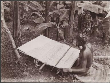A local weaver using a loom, Santa Cruz Islands, 1906 / J.W. Beattie