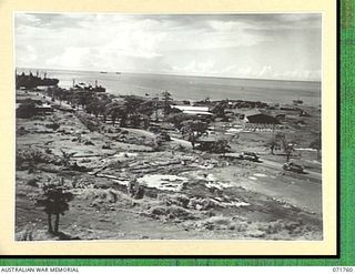 LAE, NEW GUINEAS, 1944-03-27. ONE OF A SERIES OF PHOTOGRAPHS VIEWING THE WHARVES, SHIPPING, NEW ROADS, BUILDINGS AND THE AIRSTRIP WITH SALAMAUA POINT IN THE BACKGROUND. (JOINS WITH PHOTOGRAPHS ..