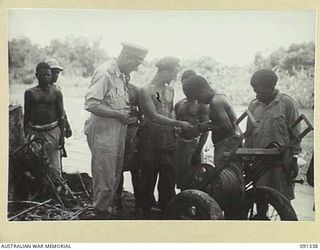 BOUGAINVILLE. 1945-04-27. MAJOR GENERAL C.H. SIMPSON, SIGNAL OFFICER IN CHIEF (1), WITH A NATIVE LINE LAYING SECTION IN CHARGE OF LANCE CORPORAL F.S. TURNER, 3 DIVISION SIGNALS (AIF) (2). MAJOR ..