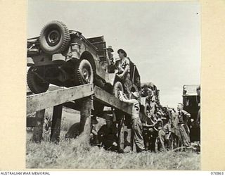 WAU, NEW GUINEA, 1944-02-20. DRIVERS OF THE 2/34TH GENERAL TRANSPORT COMPANY MAINTAINING VEHICLES UNDER SUPERVISION OF QX945 LIEUTENANT L.G. MATHAMS (9), A PLATOON COMMANDER. FREQUENT MAINTENANCE ..