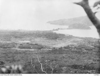 View from the observation post above Nuk Nuk, manned by members of the New Guinea Volunteer Rifles. The cleared area in the centre is the airstrip. Salamaua itself is situated on the Flat Isthmus ..