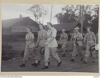 BOUGAINVILLE, 1945-04-19. AUSTRALIAN ARMY MEDICAL WOMEN'S SERVICE 2/1 GENERAL HOSPITAL PERSONNEL LEAVING THE COMPOUND FOR DUTY AT 0730 HOURS (7.30 AM). IDENTIFIED PERSONNEL ARE:- PRIVATE M. ..