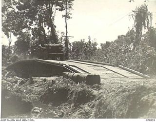 BOUGAINVILLE ISLAND. 1945-02-04. A JEEP AND TRAILER CARRYING SUPPLIES TO FORWARD AUSTRALIAN UNITS CROSSING A NEW BOX GIRDER BRIDGE BUILT BY MEMBERS OF THE 5TH FIELD COMPANY, ACROSS A SMALL CREEK ON ..