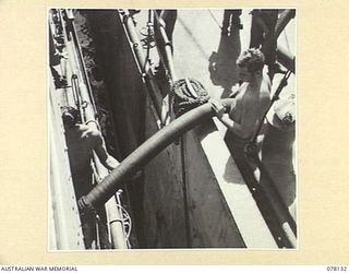 MIOS WUNDI, DUTCH NEW GUINEA. 1944-11-17. RATINGS STEADYING THE OIL PIPE FROM THE USS VICTORIA, A UNITED STATES OIL TANKER, TO THE ROYAL AUSTRALIAN NAVY CORVETTE HMAS GLENELG DURING REFUELLING ..