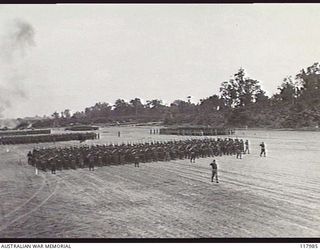 TOROKINA, BOUGAINVILLE. 1945-10-29. PERSONNEL OF ROYAL AUSTRALIAN ARTILLERY GIVE EYES RIGHT AS THEY MOVE PAST THE SALUTING BASE WHERE THE COMMANDER IN CHIEF, AUSTRALIAN MILITARY FORCES, TAKES THE ..