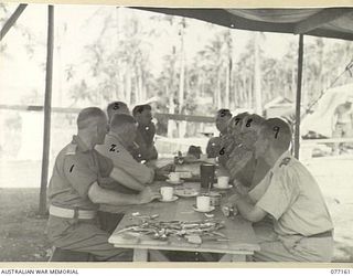 JACQUINOT BAY, NEW BRITAIN. 1944-11-21. RAN, AMF AND RAAF OFFICERS HOLDING A CONFERENCE IN THE MESS AT THE 5TH BASE SUB AREA REGARDING THE PROPOSED AIRSTRIP IN THE PALMALMAL PLANTATION. IDENTIFIED ..