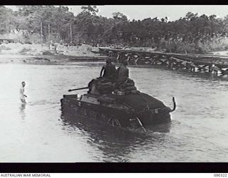 BOUGAINVILLE, 1945-04-04. A MATILDA TANK FROM 8 TROOP, B SQUADRON, 2/4TH ARMOURED REGIMENT, CROSSING THE PURIATA RIVER, WITH THE OLD MCKINNA BRIDGE IN THE BACKGROUND. THE TANKS MOVED UP FROM TOKO ..